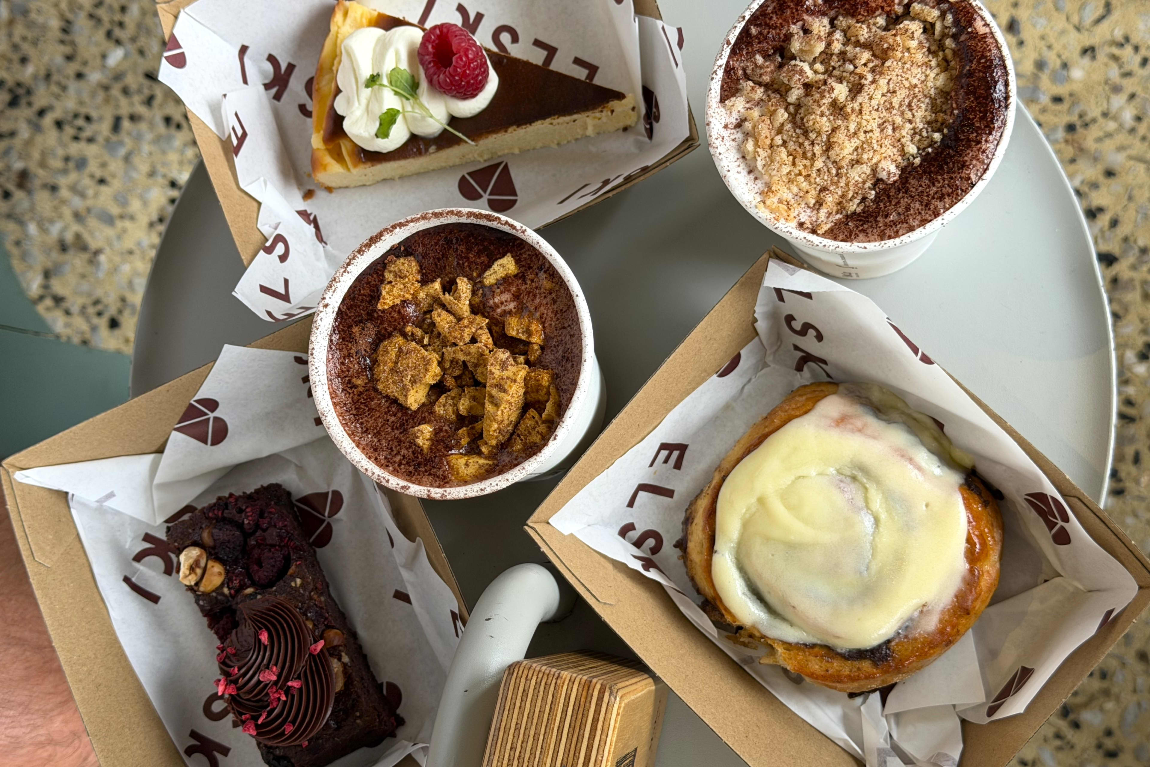 An overhead shot of an assortment of desserts arranged on a round white table.