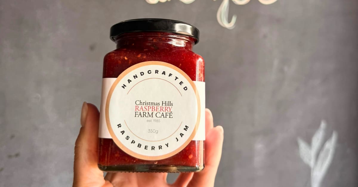 Hand holds jar of raspberry jam