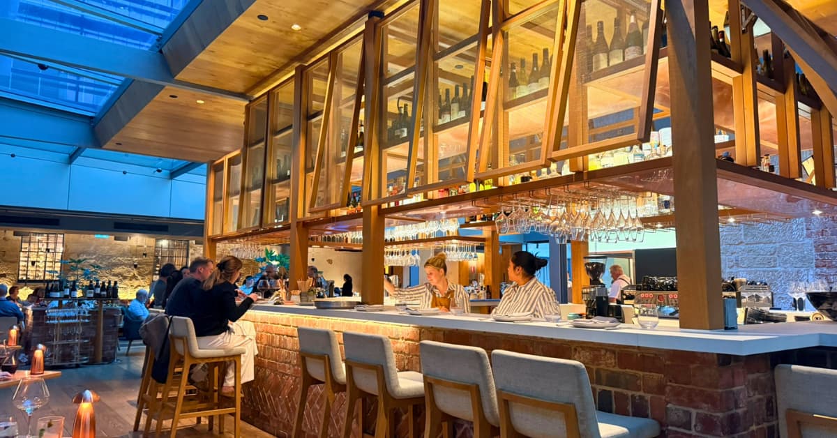 Inside restaurant with central bar and people seated at stools