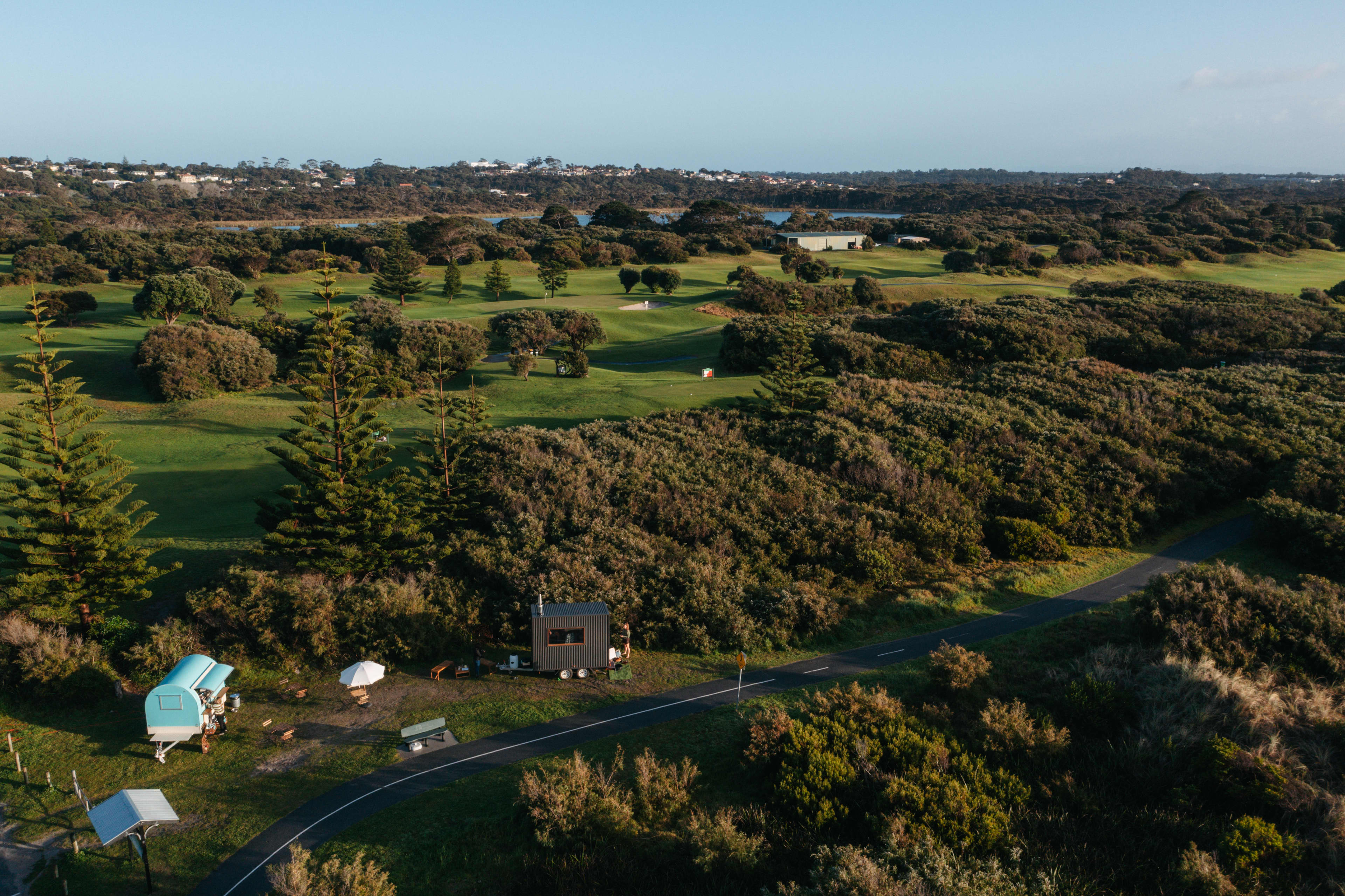 Aerial view of sauna among bushland, golf course and lake.