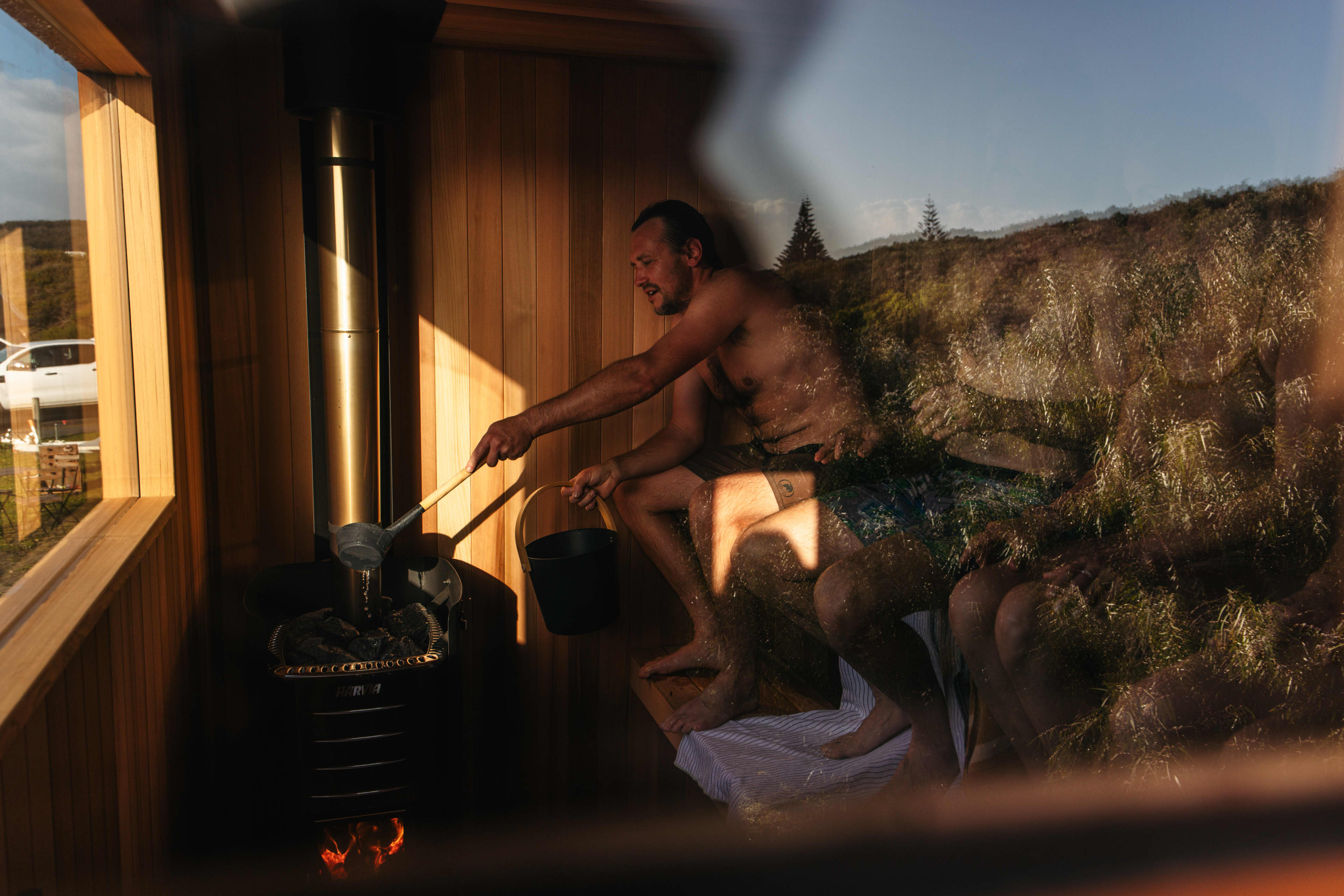Men inside sauna pouring water
