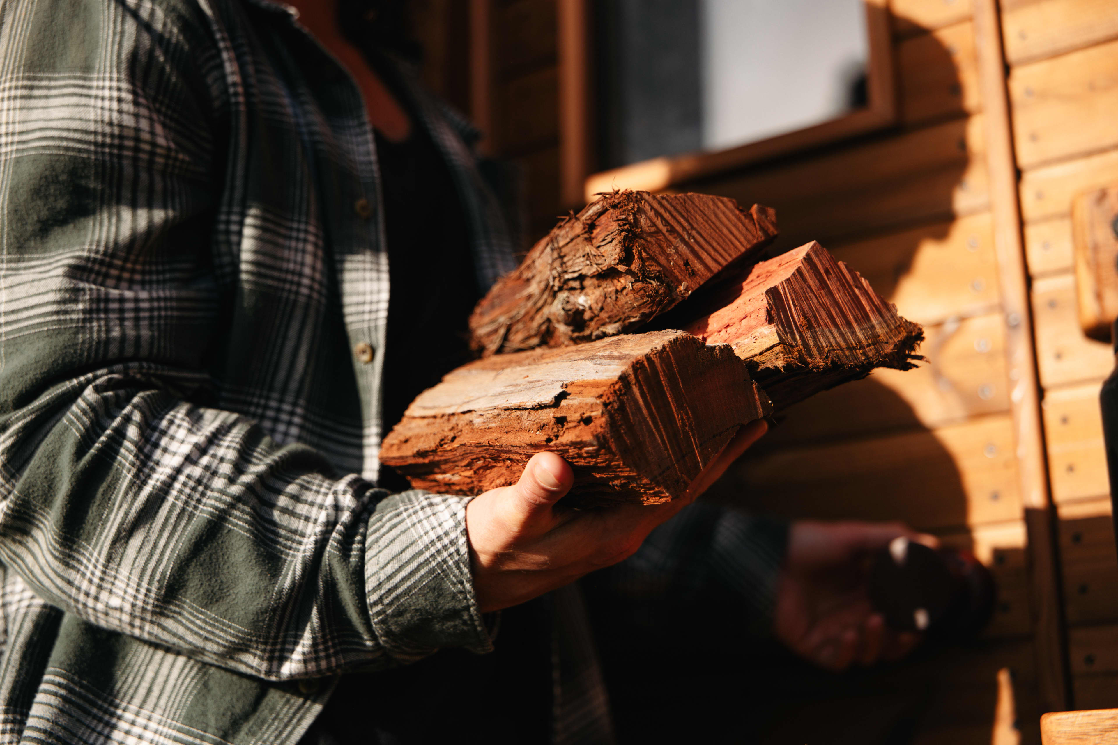 Man holding pile of firewood