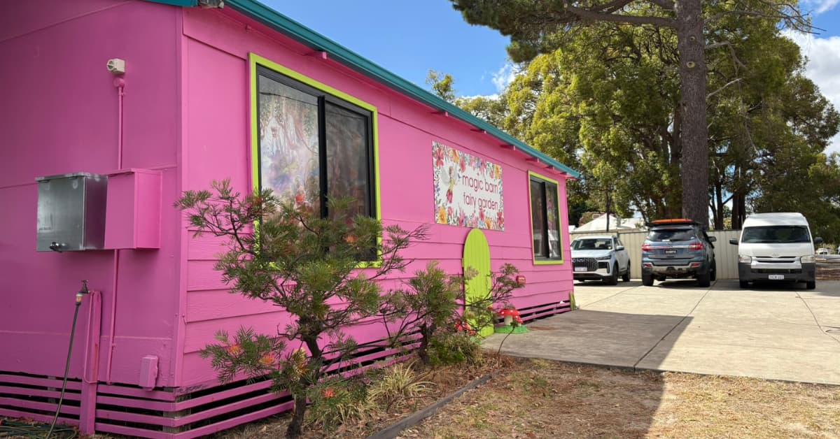 Bright pink building with sign that reads Magic Barn Fairy Garden