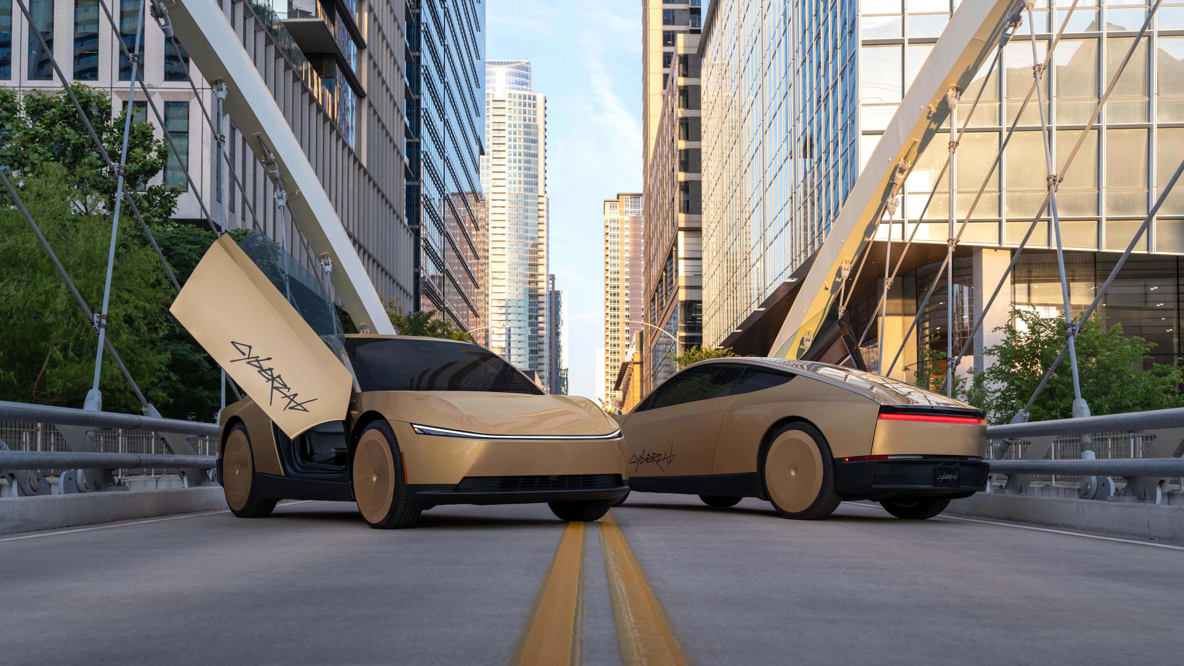 Two gold futuristic looking cars, one with its scissor door open upwards with Cybercab written in black, parked in the middle of a city road with skyscrapers in the background.