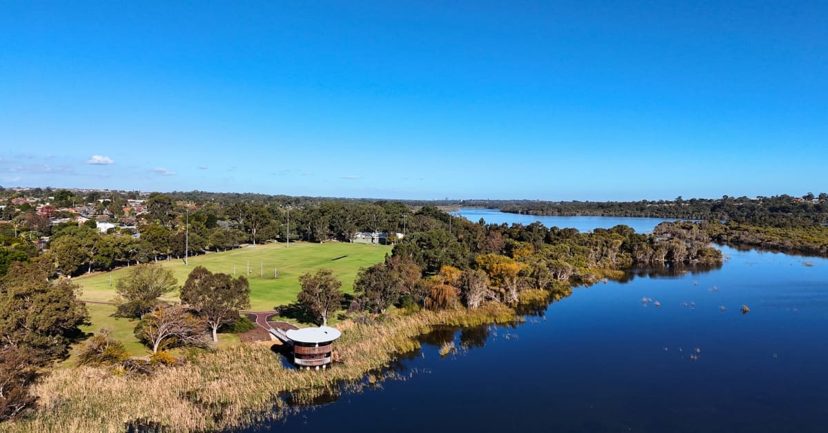 Large blue lake with double storey viewing tower in reeds on the banks of lake.