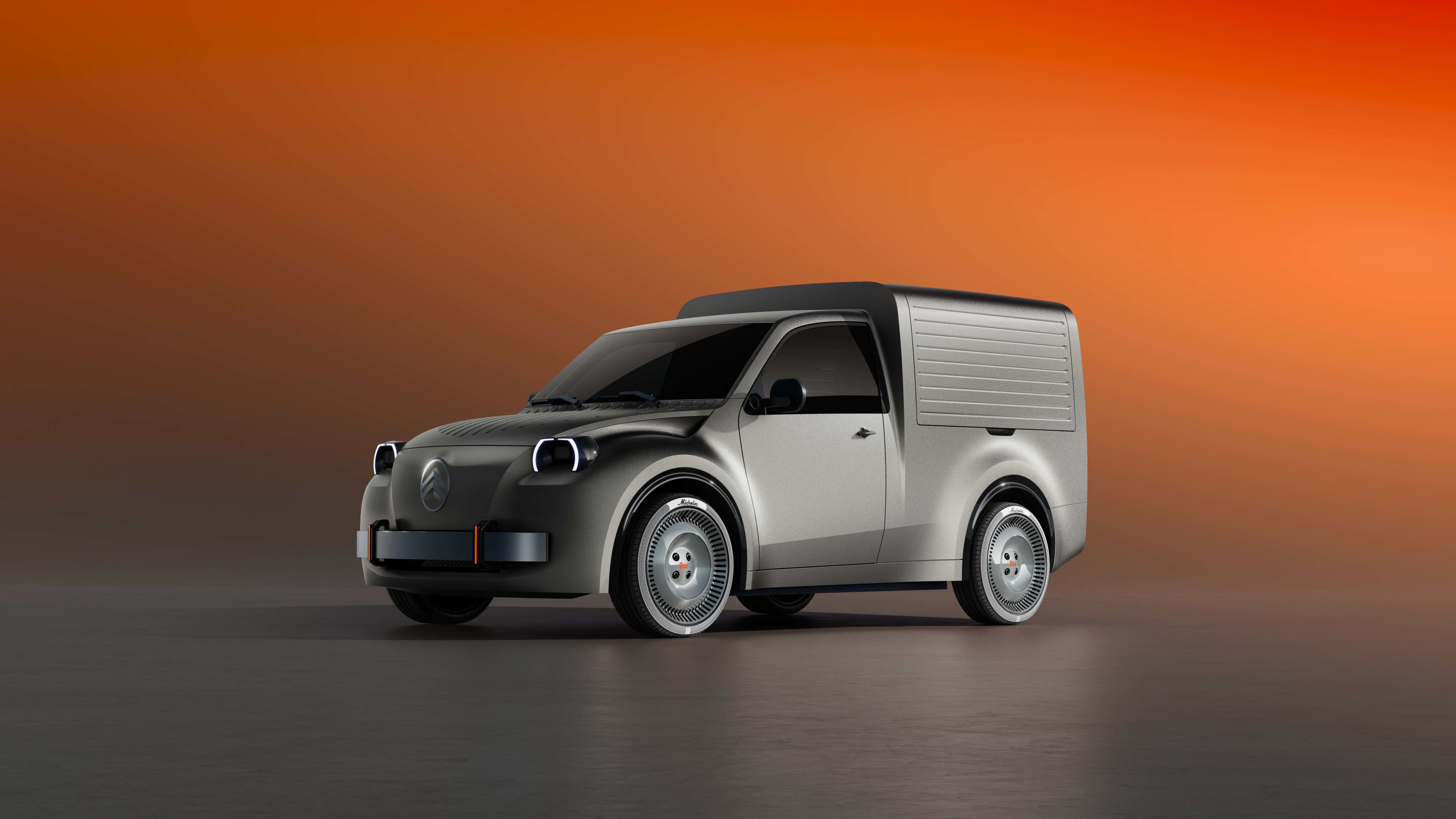 A silver panel van in a grey and orange studio.