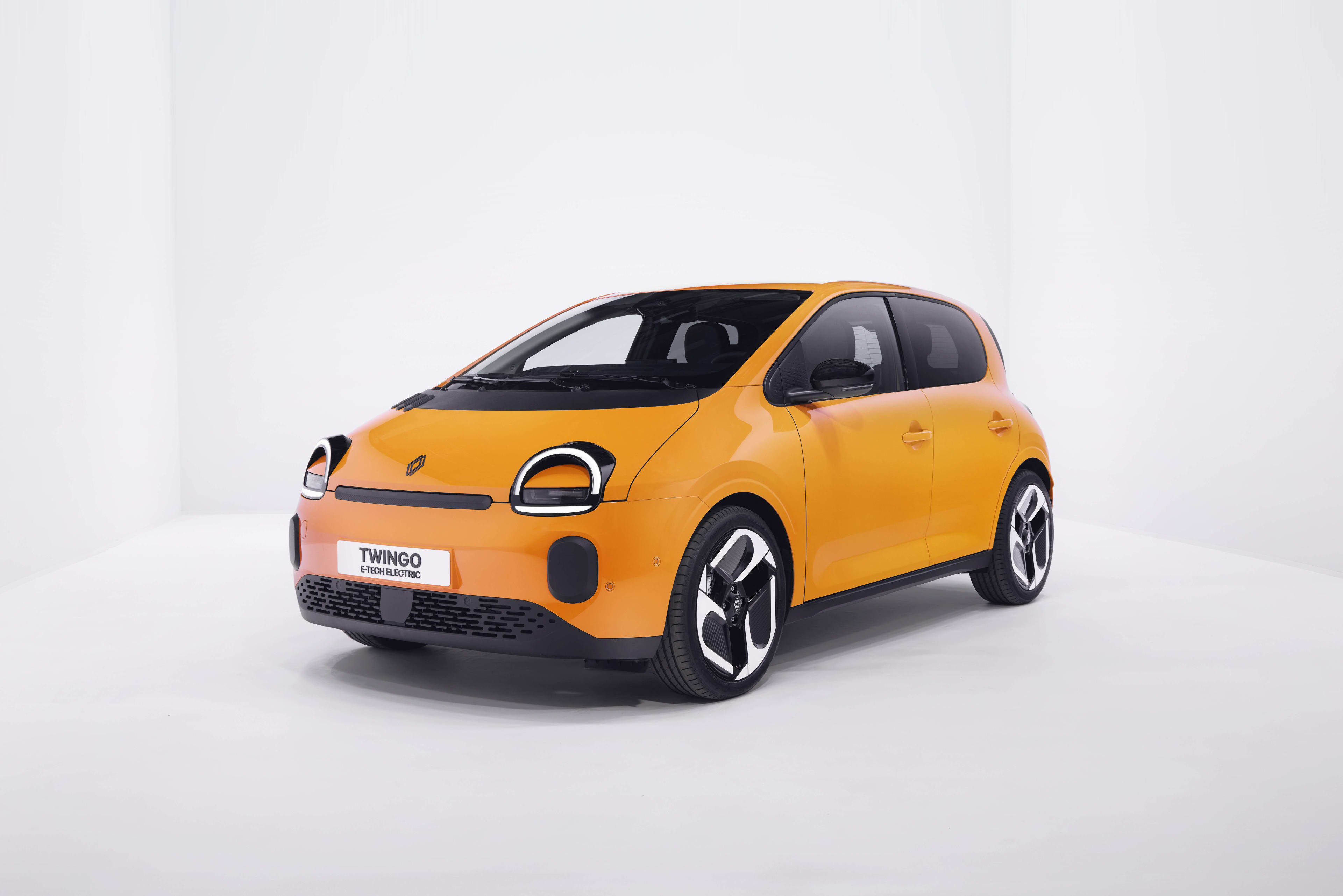 A yellow Renault Twingo E-Tech in a white studio backdrop.