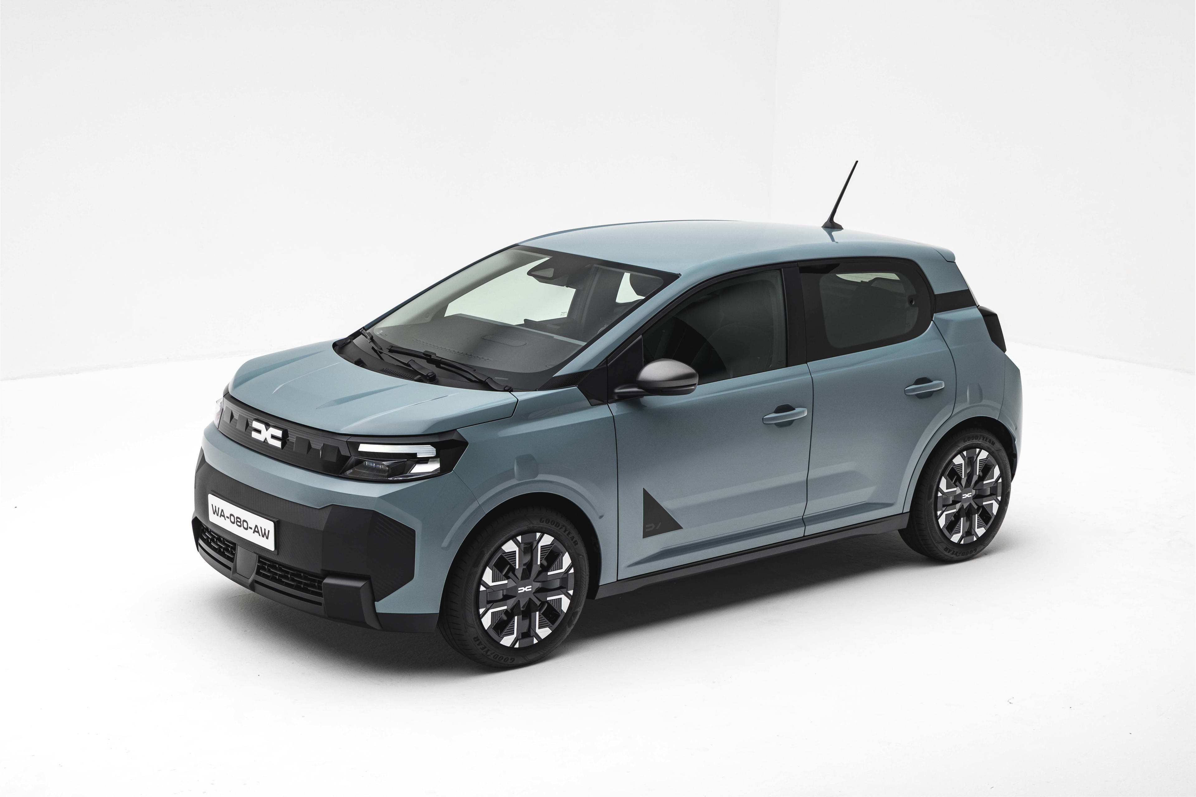 A blue-green Dacia Spring EV against a white studio backdrop.