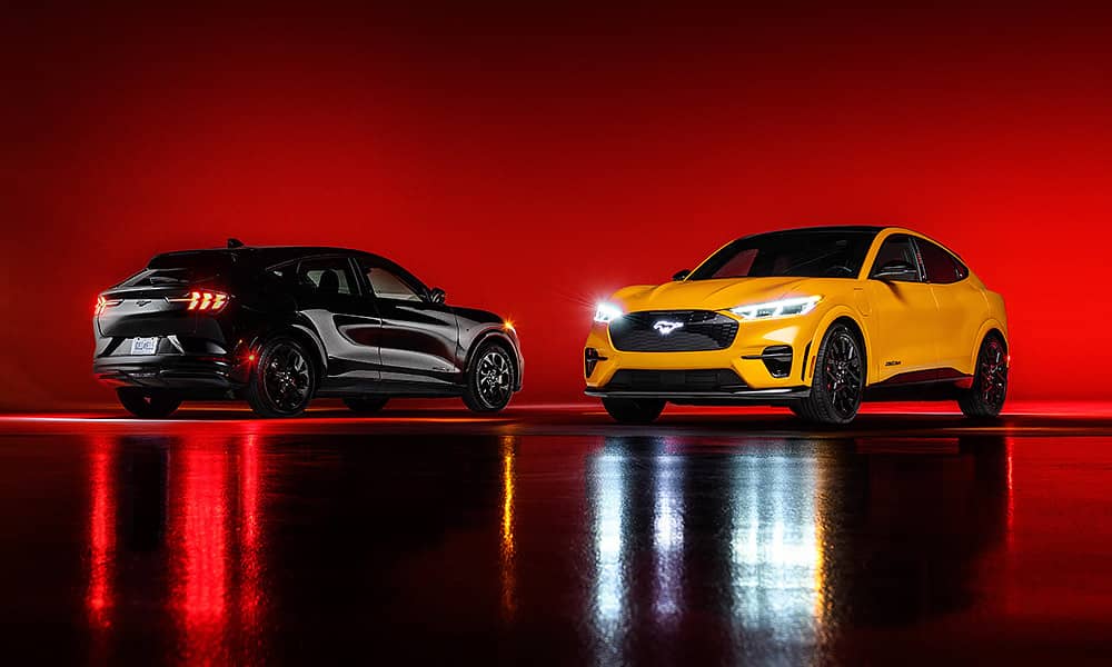 Two Ford Mustang Mach Es in a studio setting lit with red light