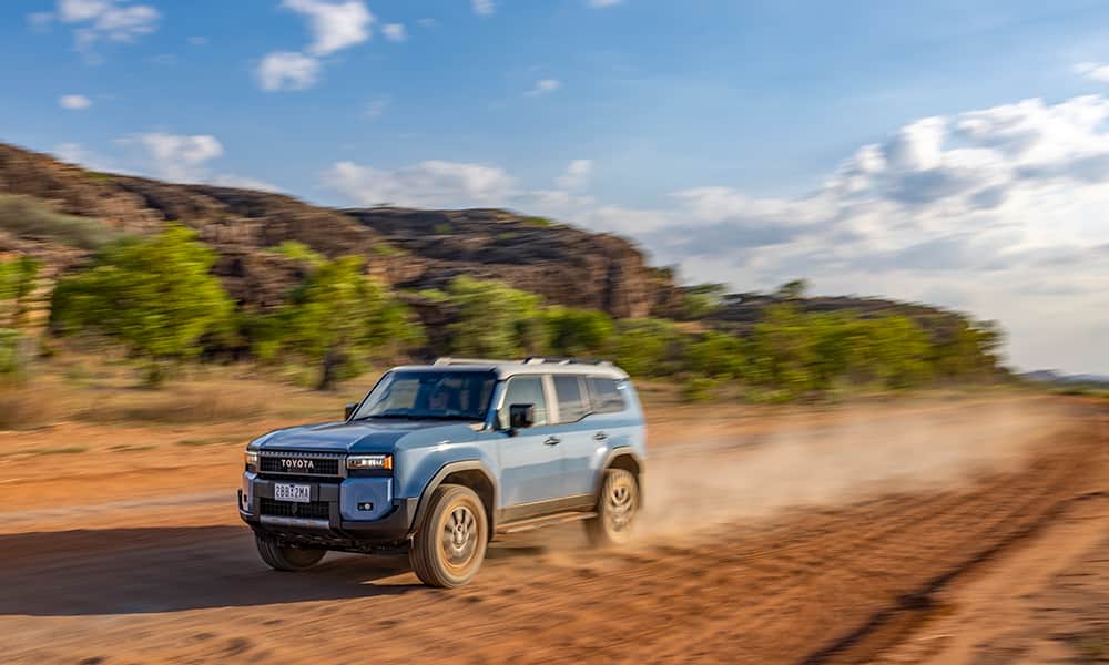 A 2024 Toyota Prado driving along an outback gravel road