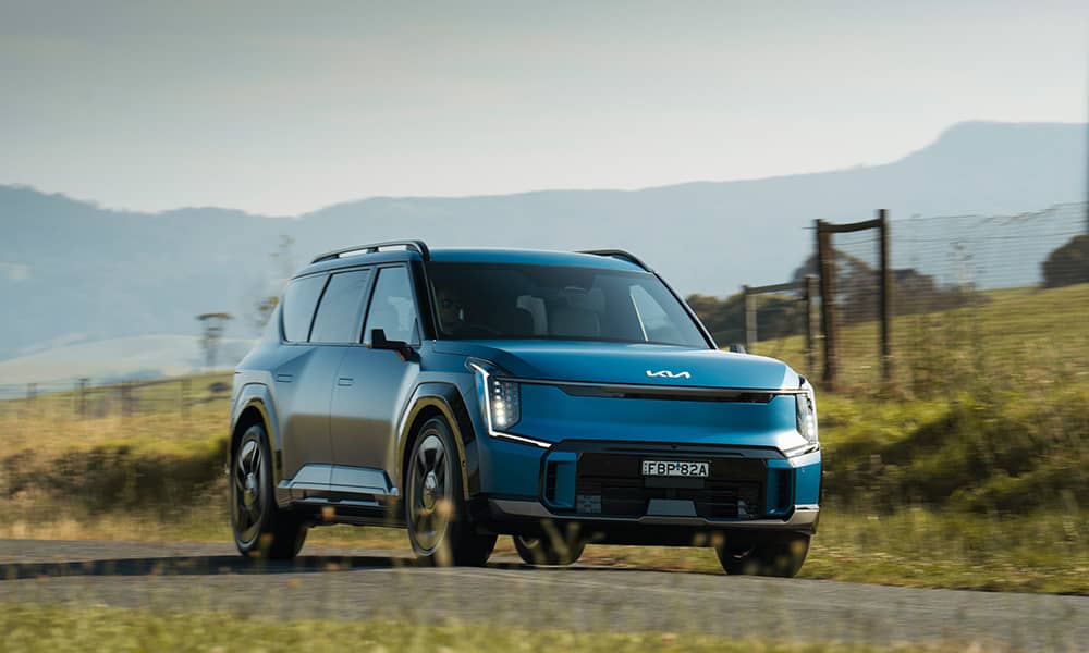 Kia EV9 driving down a country road