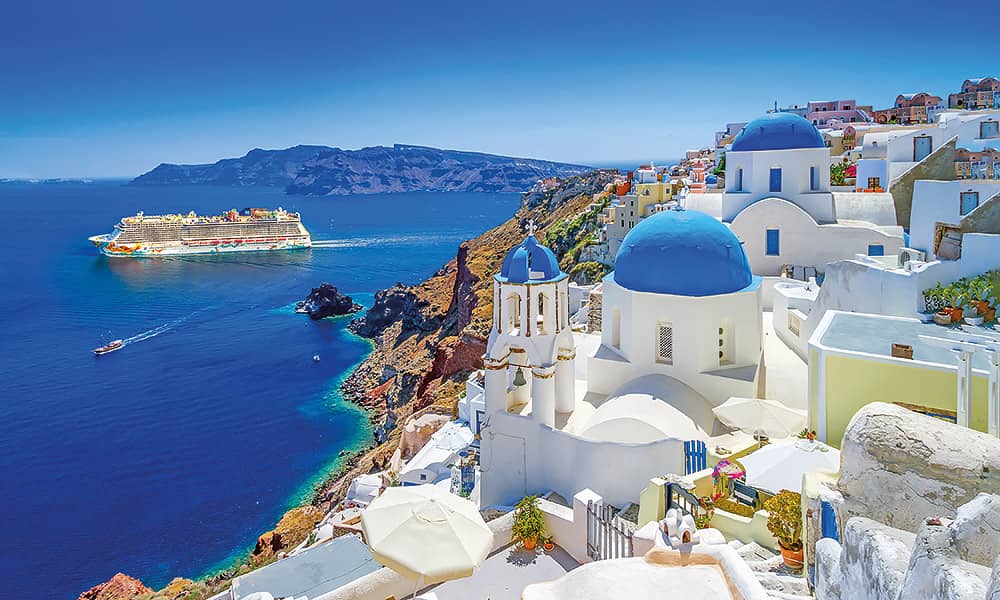 A ship cruising the Mediterranean with a mountainous landscape in the distance