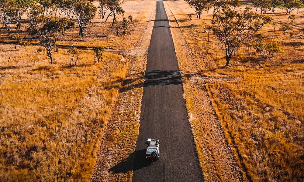 A four-wheel drive on a rural road in summer