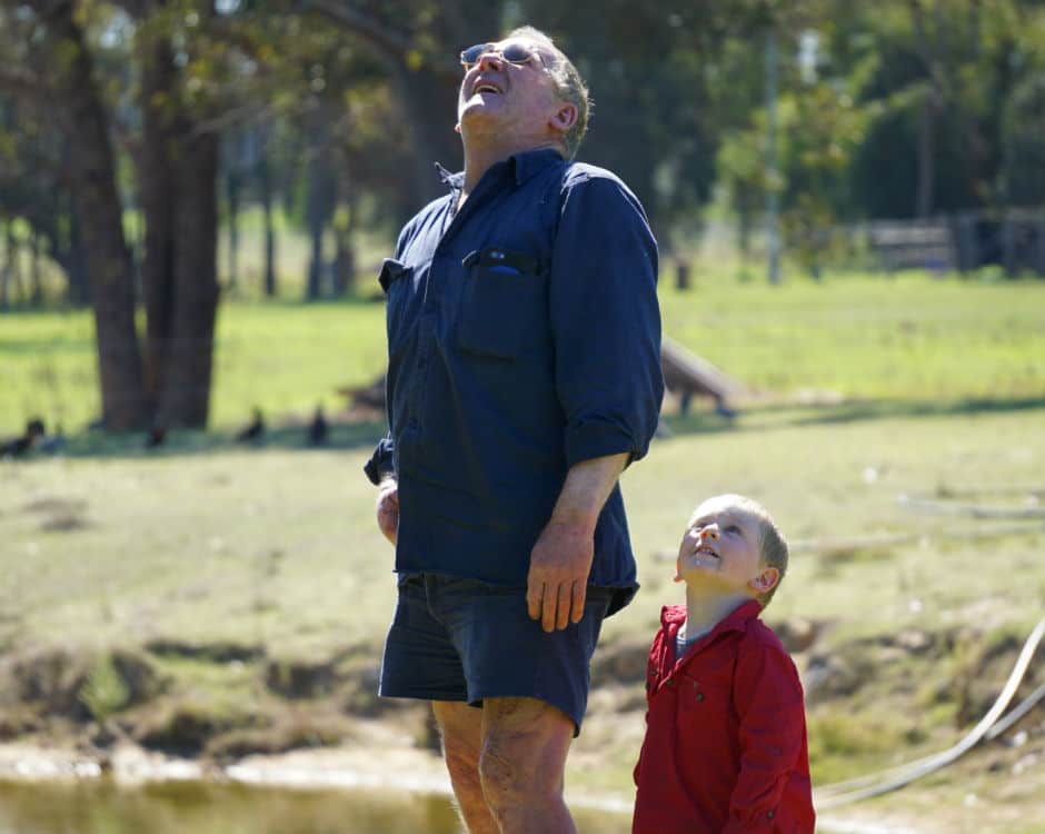 Jim Roney and his grandson Kane watch an RAC Rescue helicopter flying overhead