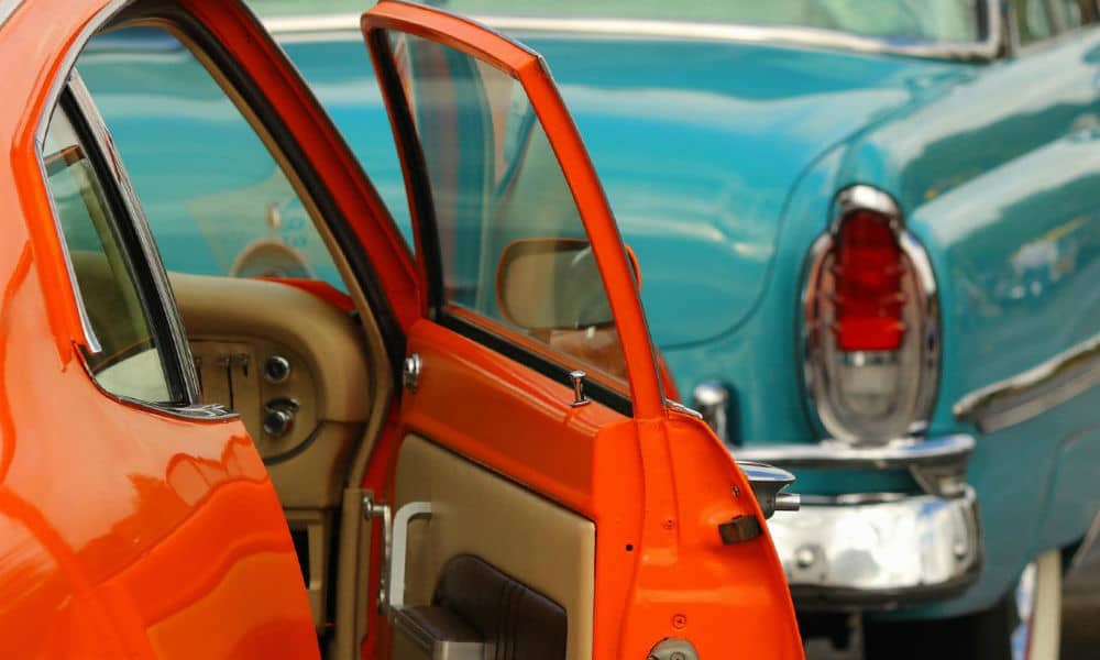 An orange vintage car with the door open