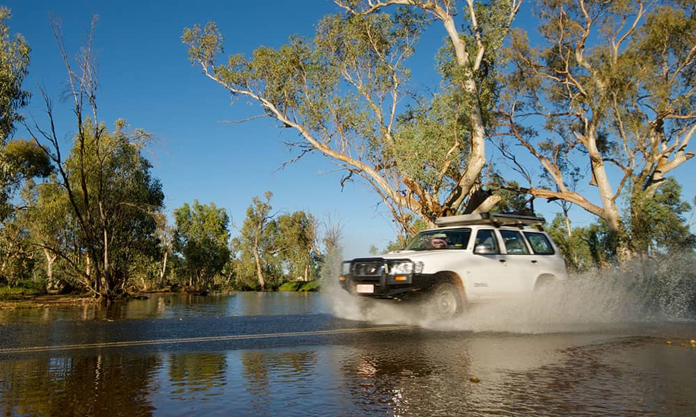 A four wheel drive crossing a body of water