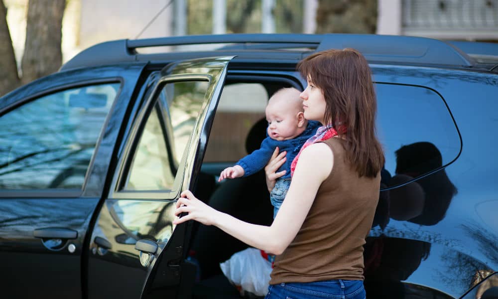 A mother putting her baby into the car