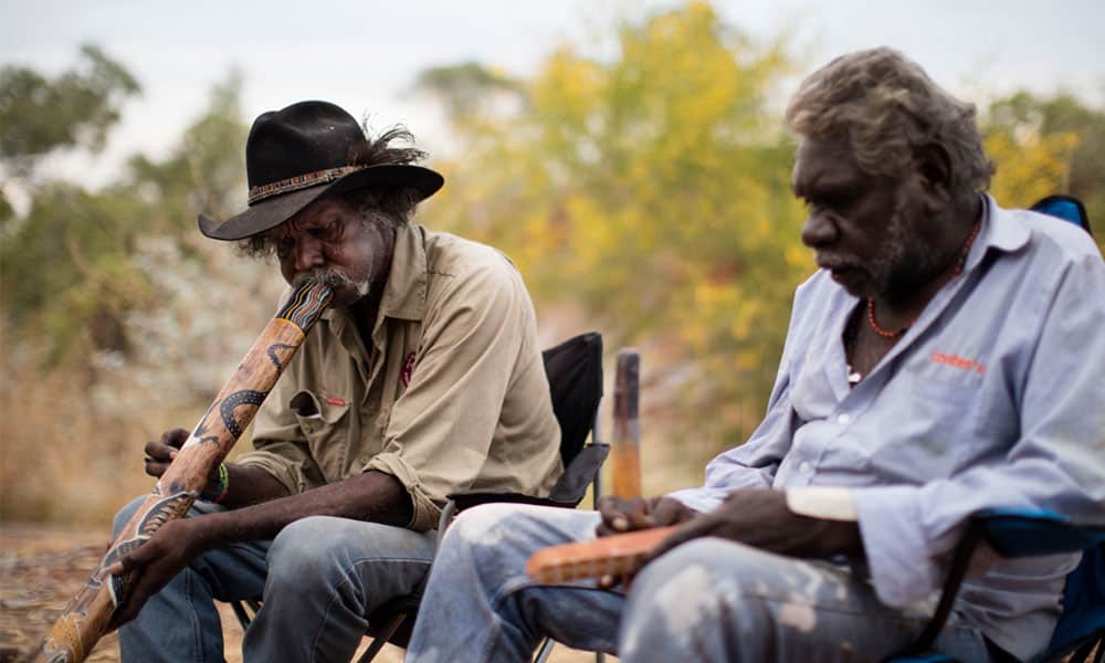 An Indigenous man playing a didgeridoo on a tour from Waringarri Aboriginal Arts