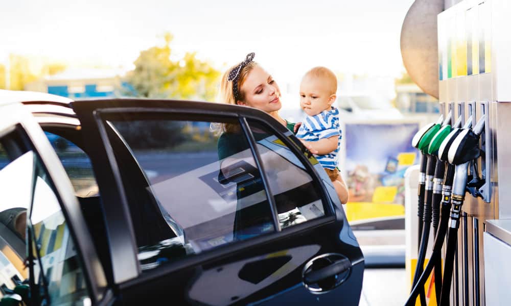 A mother holding her baby at a petrol station