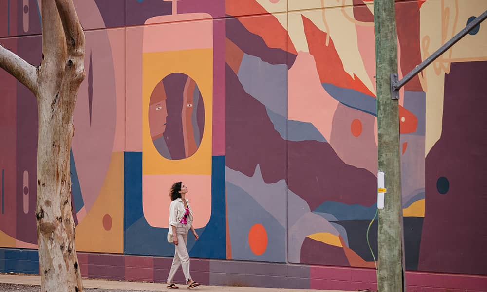 Woman walking next to mural
