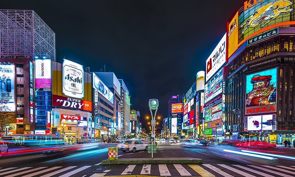 A busy Tokyo street at night with brightly coloured neon signs