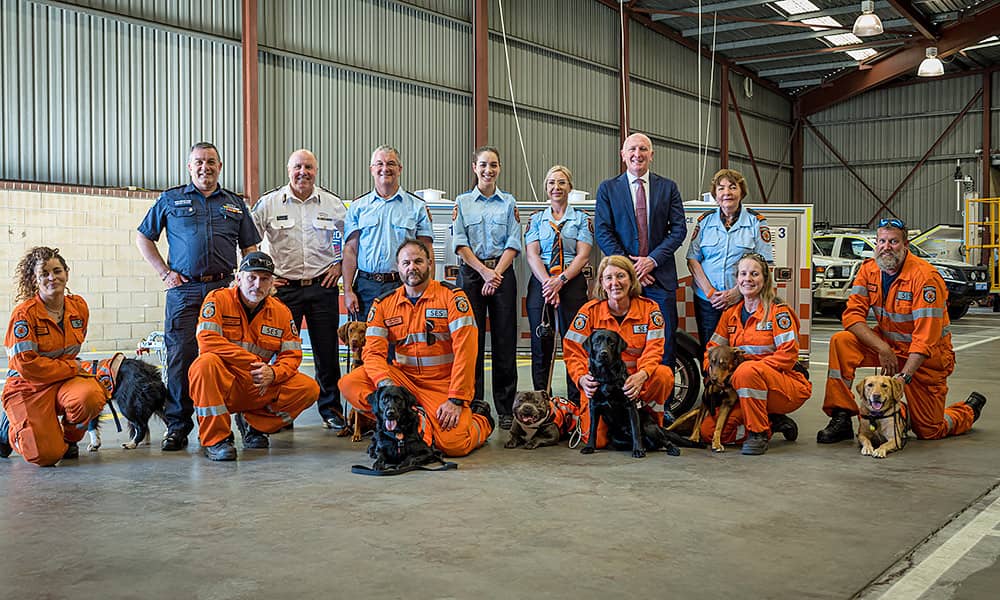 A group of canine rescue unit volunteers and their dogs pose for the camera