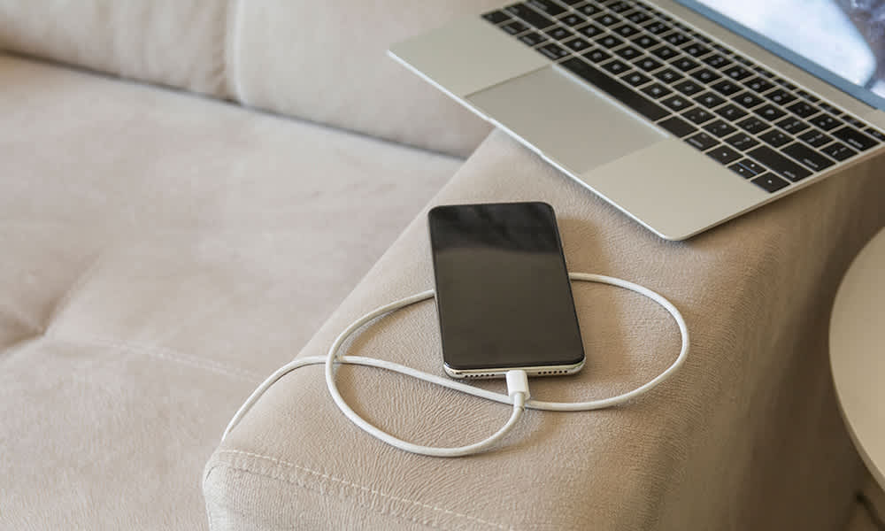 Phone charging on a soft couch