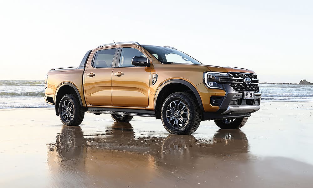 A gold Ford Ranger parked on a beach