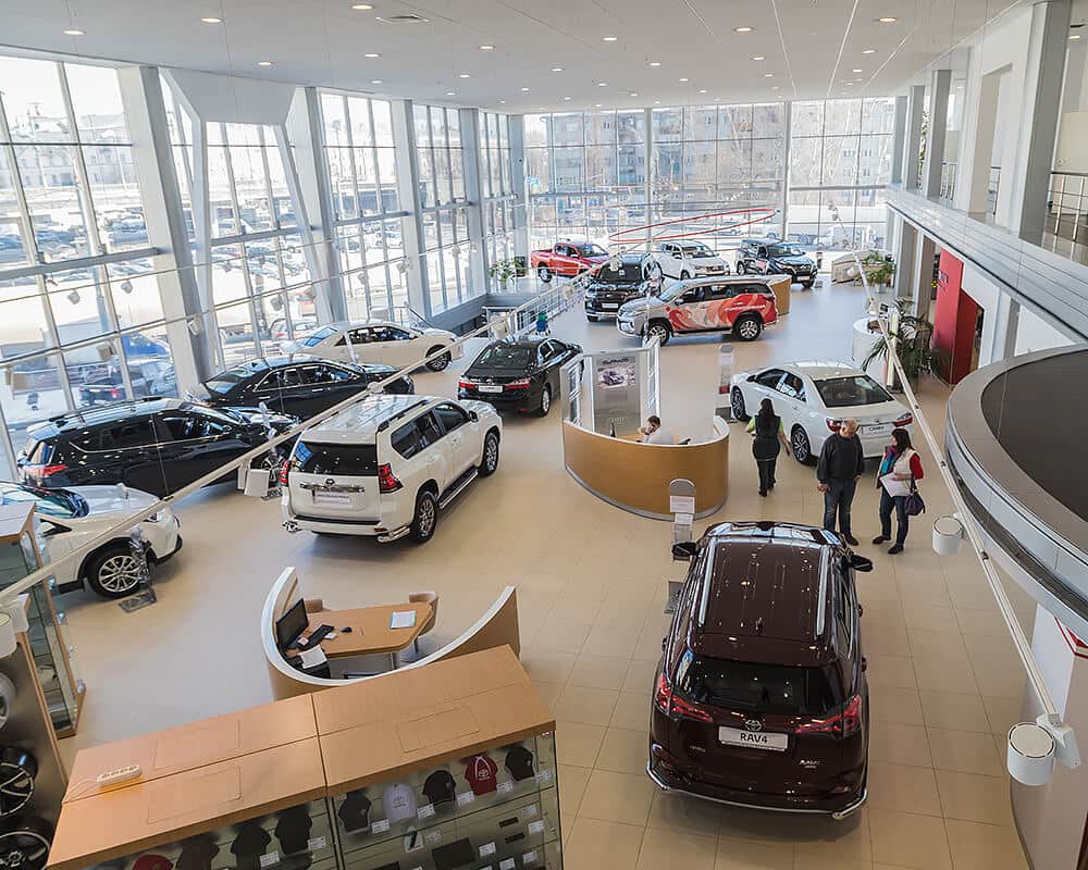 A car dealership showroom with people browsing cars