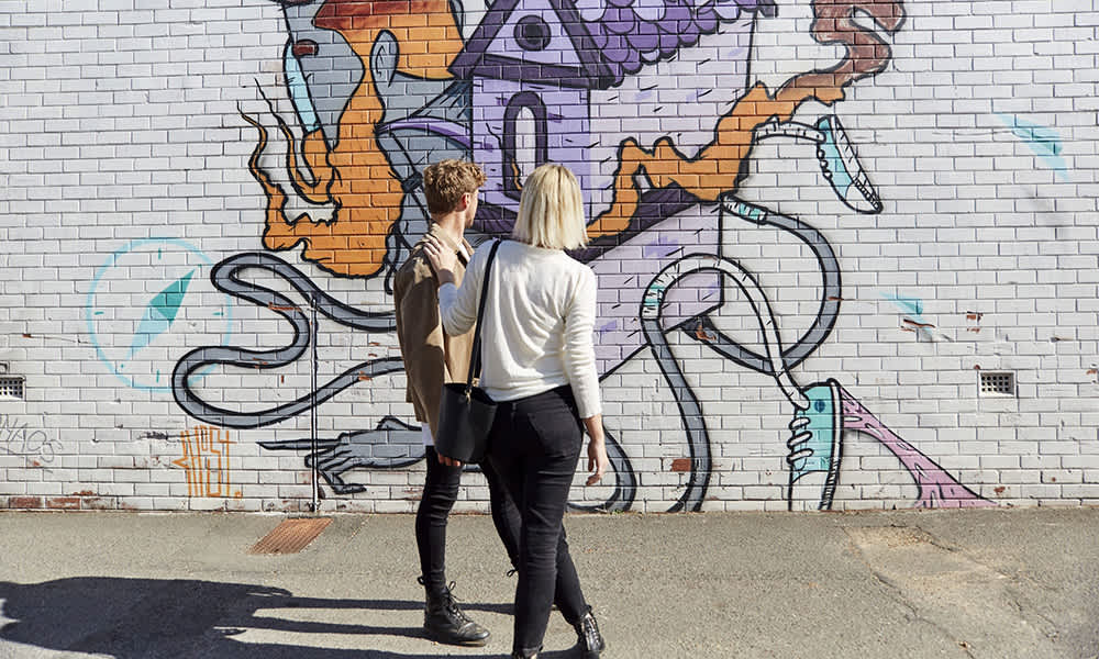 Couple standing in front of a mural