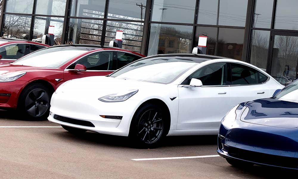 A row of Teslas on sale at a car dealership