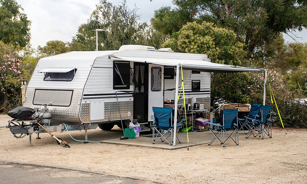 A caravan parked on a concrete pad with awning extended
