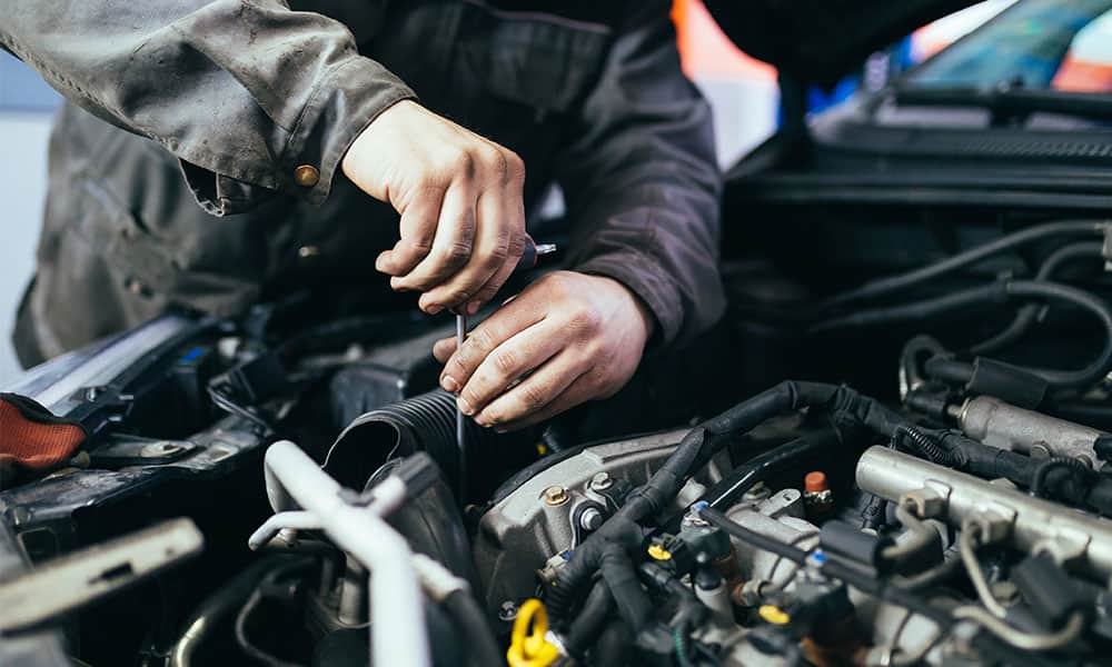 A mechanic looking at a car during a service