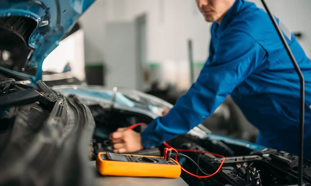 Mechanic checking car battery charge
