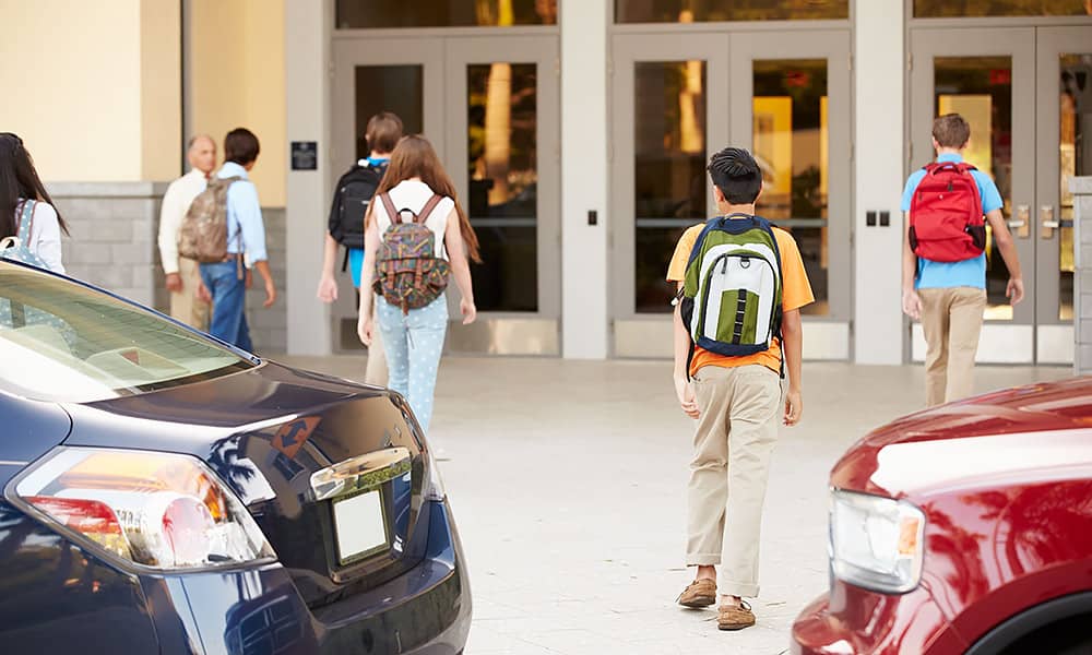 Cars dropping off children in front of a school