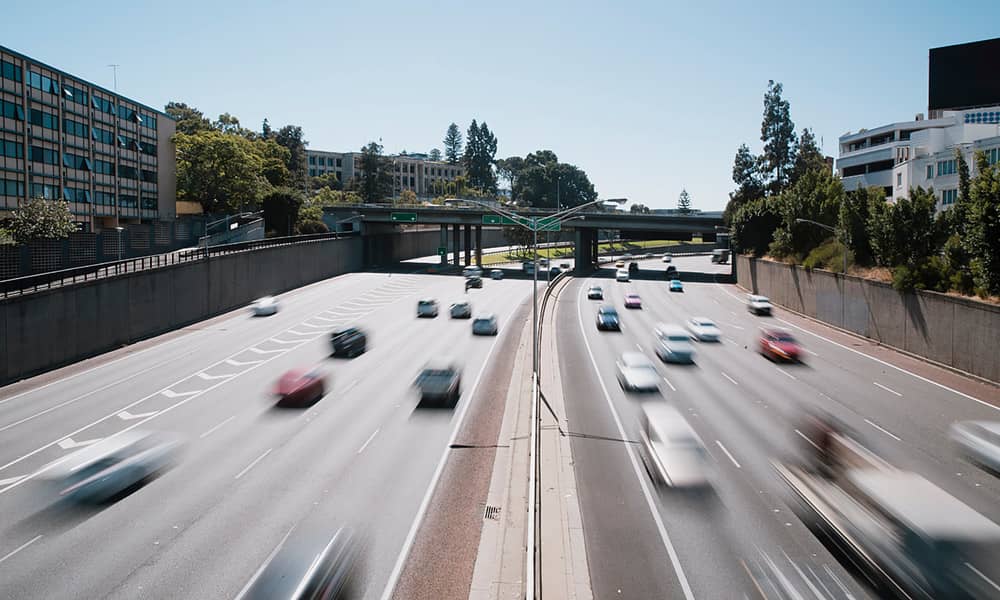 Cars driving under freeway bridge
