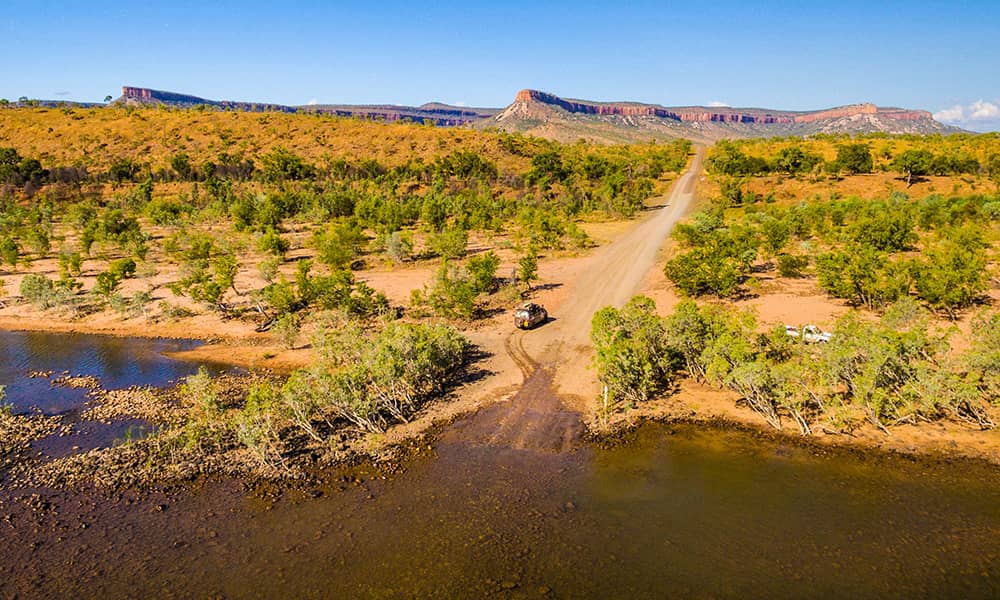 Car driving down long outback road