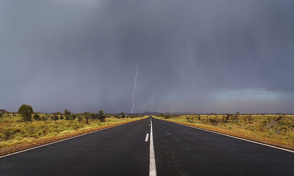 A lightning strike over a remote country road during a storm
