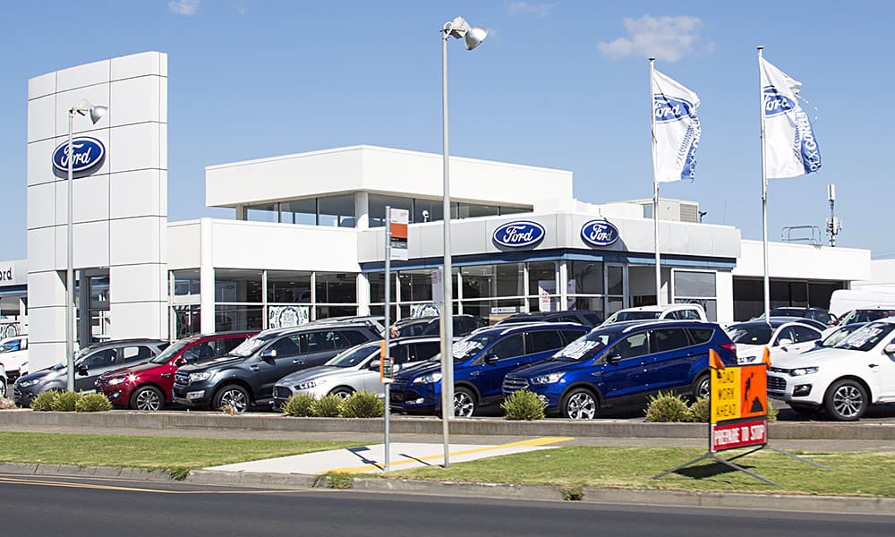 A Ford car dealership seen from the roadside