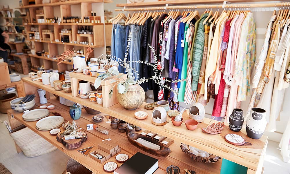 The interior of a gift store showing shelves and racks of homewares and clothing