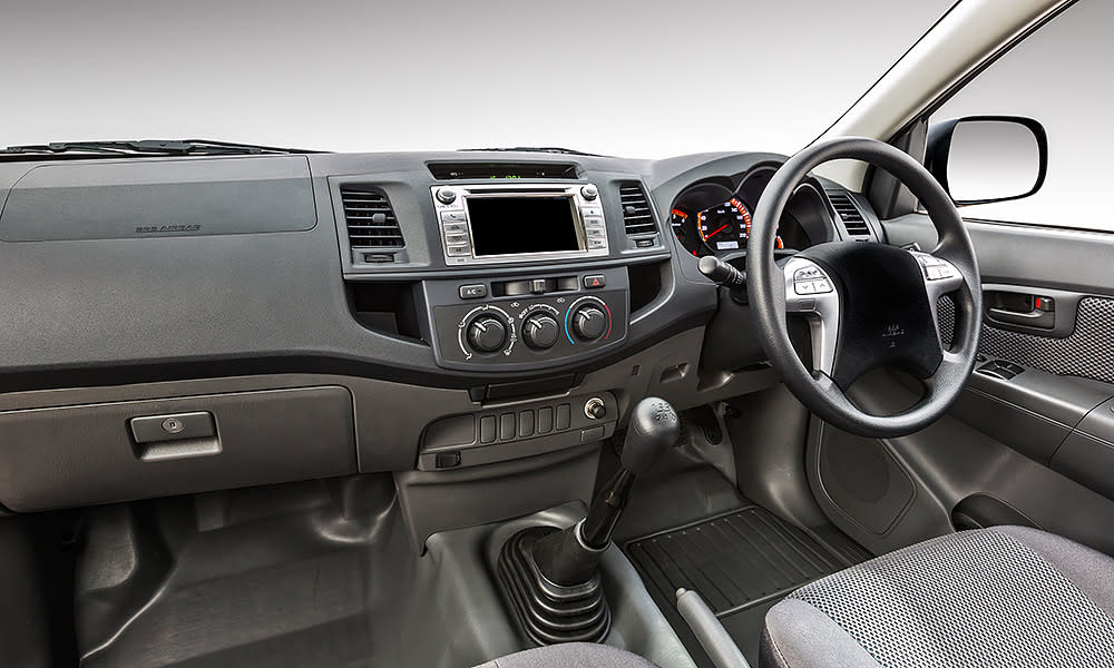 The interior of a car showing the dashboard, steering wheel and gear stick
