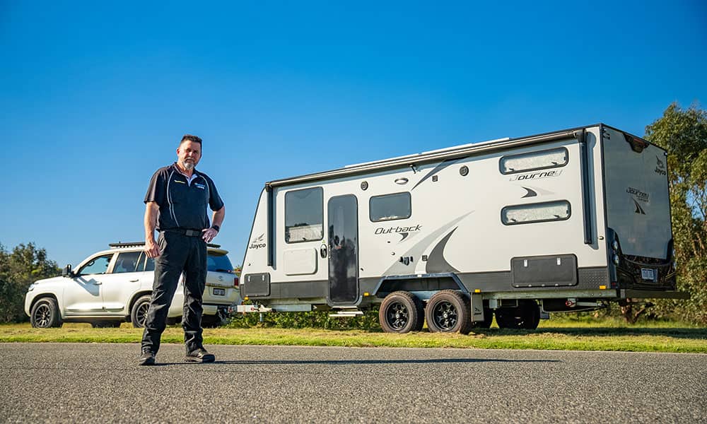 Instructor standing in front of caravan and car