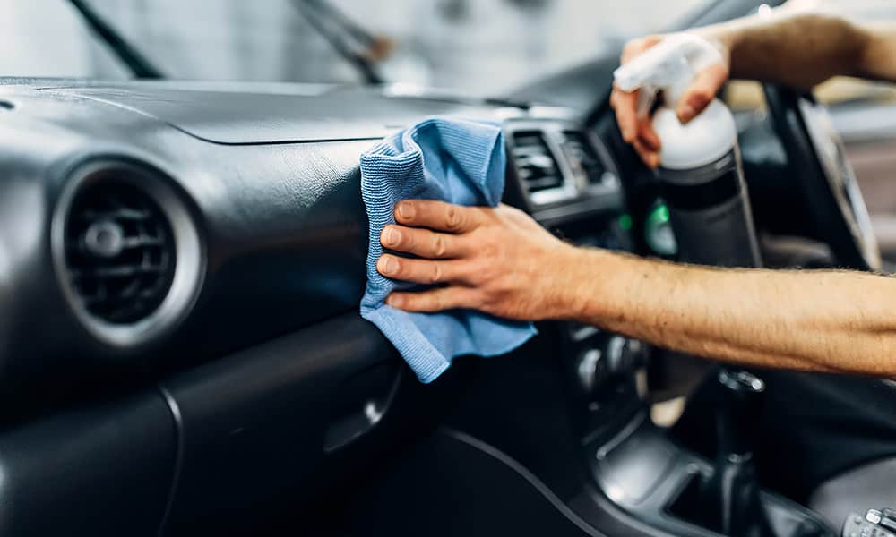 A close-up of someone polishing a dashboard