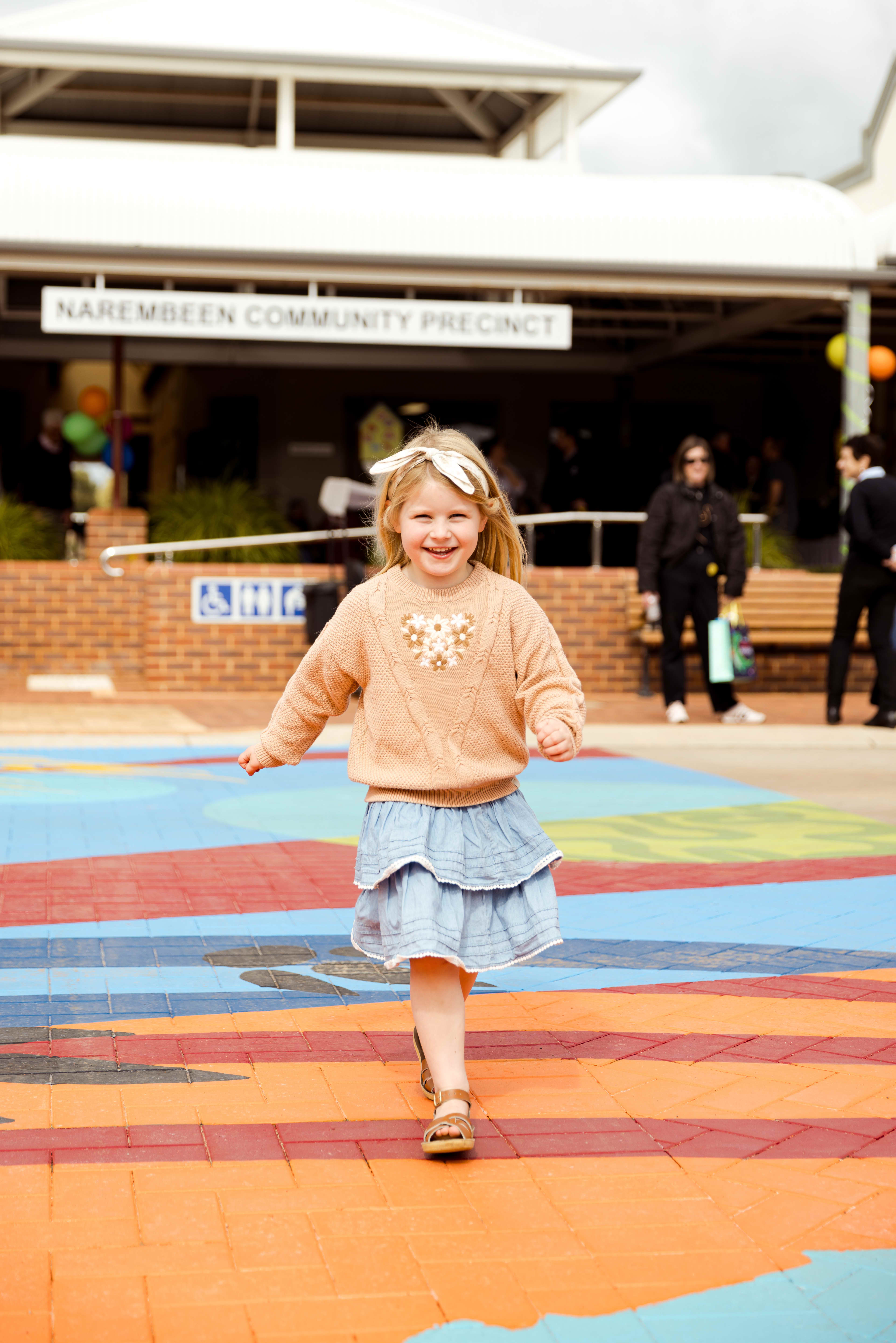 Girl running across a colourful mural.