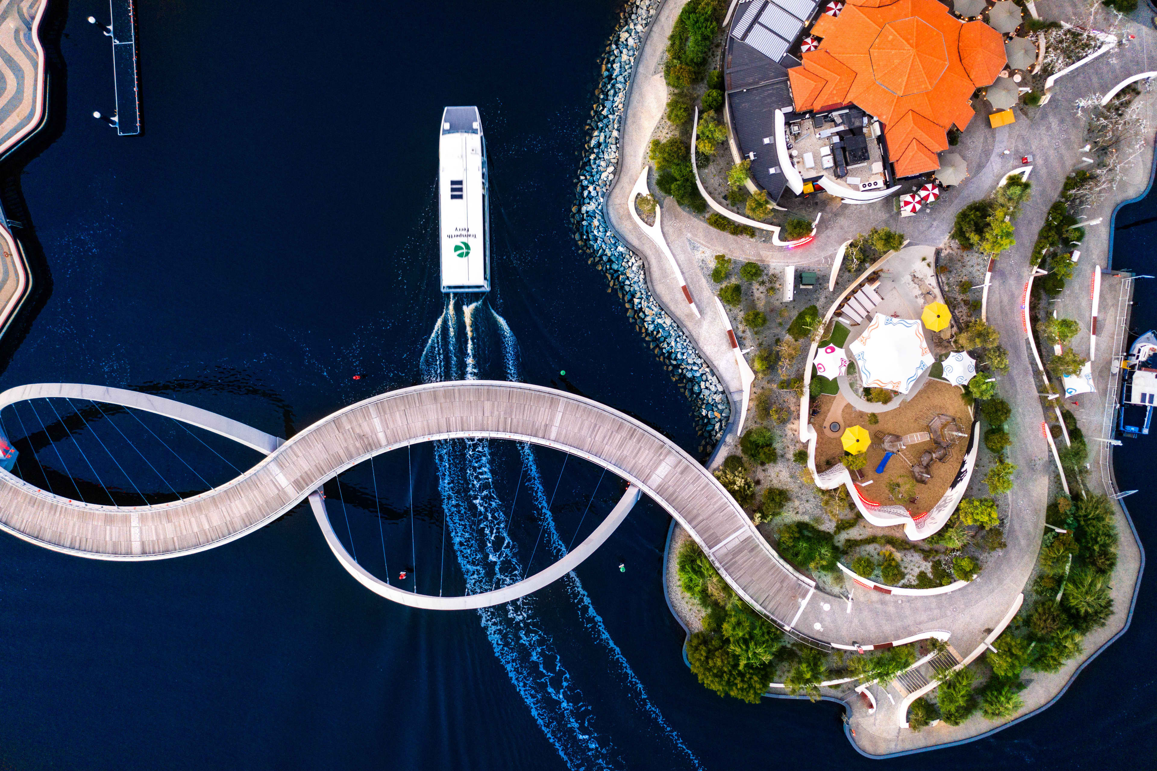 Aerial view of ferry passing under a bridge on the Swan River in Perth, WA