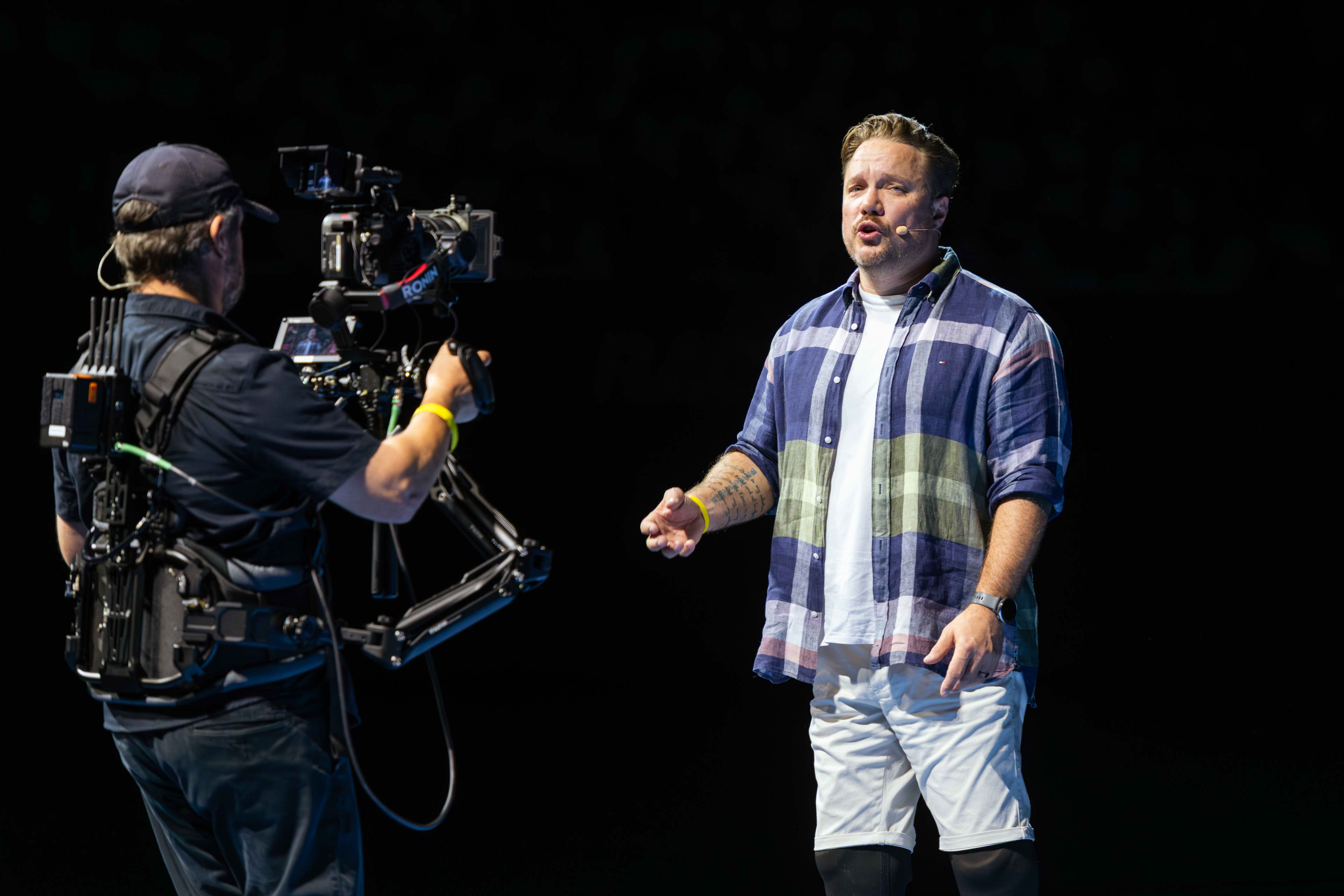 Cameraman filming speaker at public event.