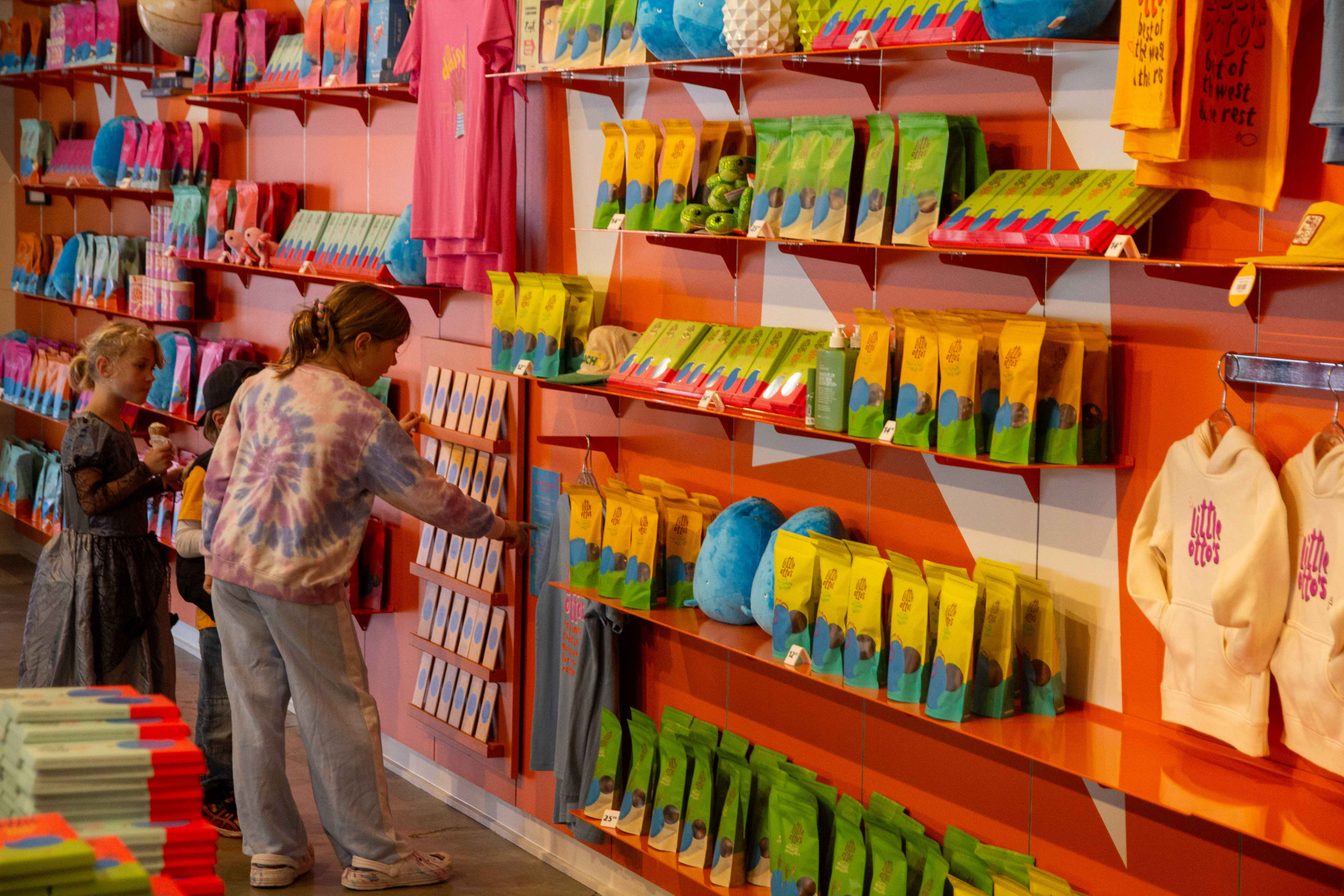 Two young children looking at wall of chocolates available to buy at Little Otto's Big Choc Shop