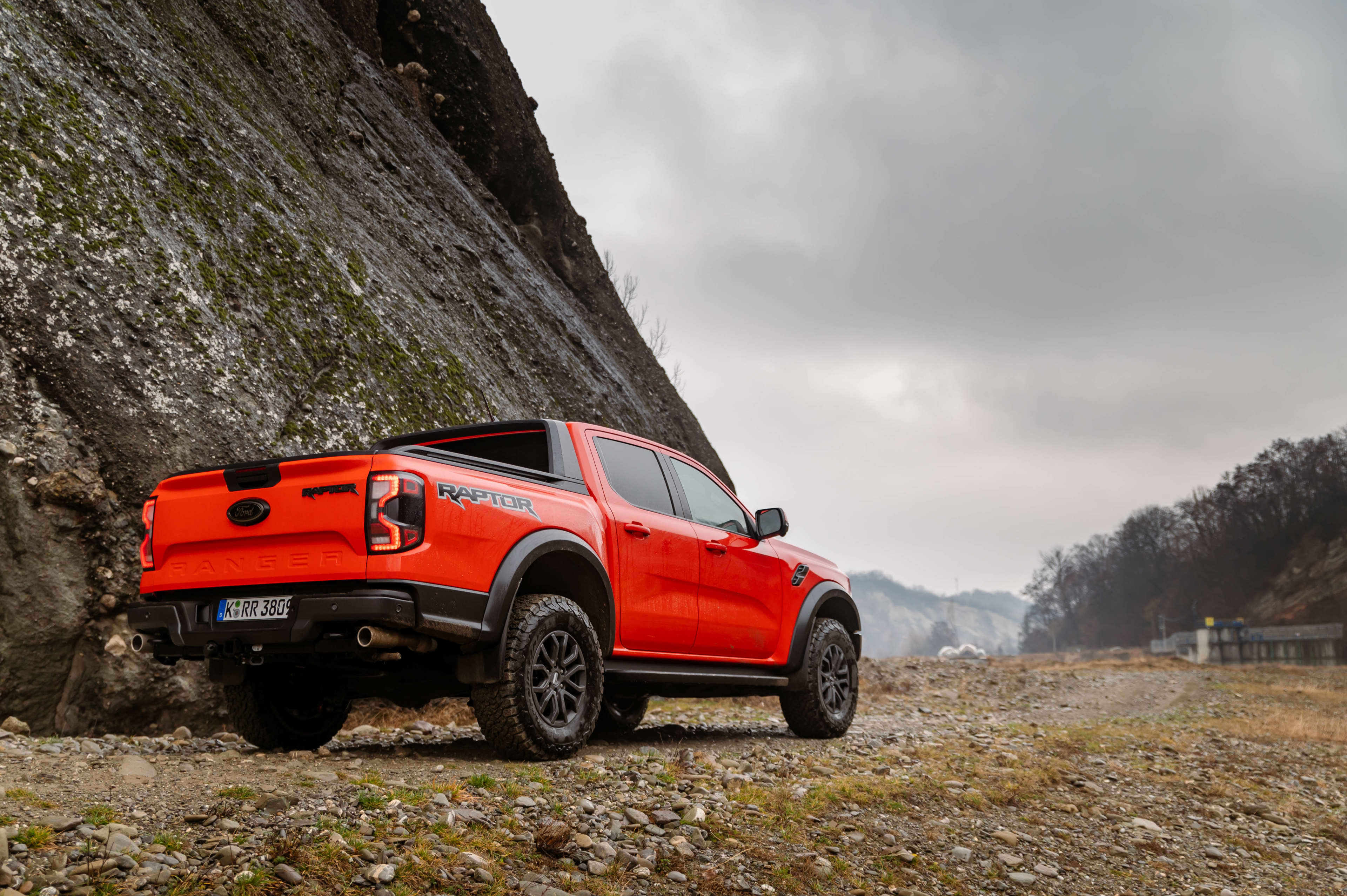 A red Ford Ranger Raptor parked at the bade of a cliff