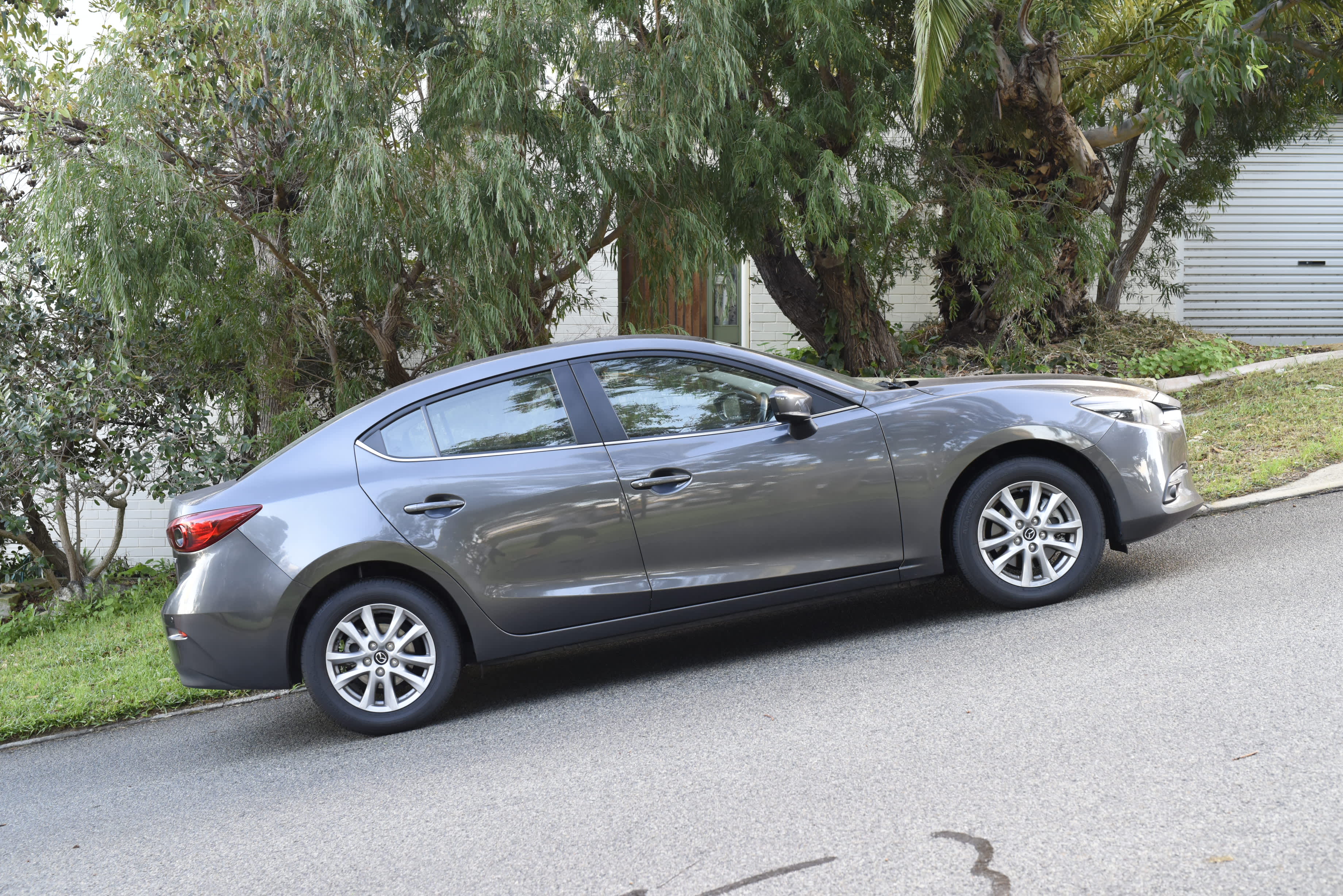 A grey car parked on a steep suburban street