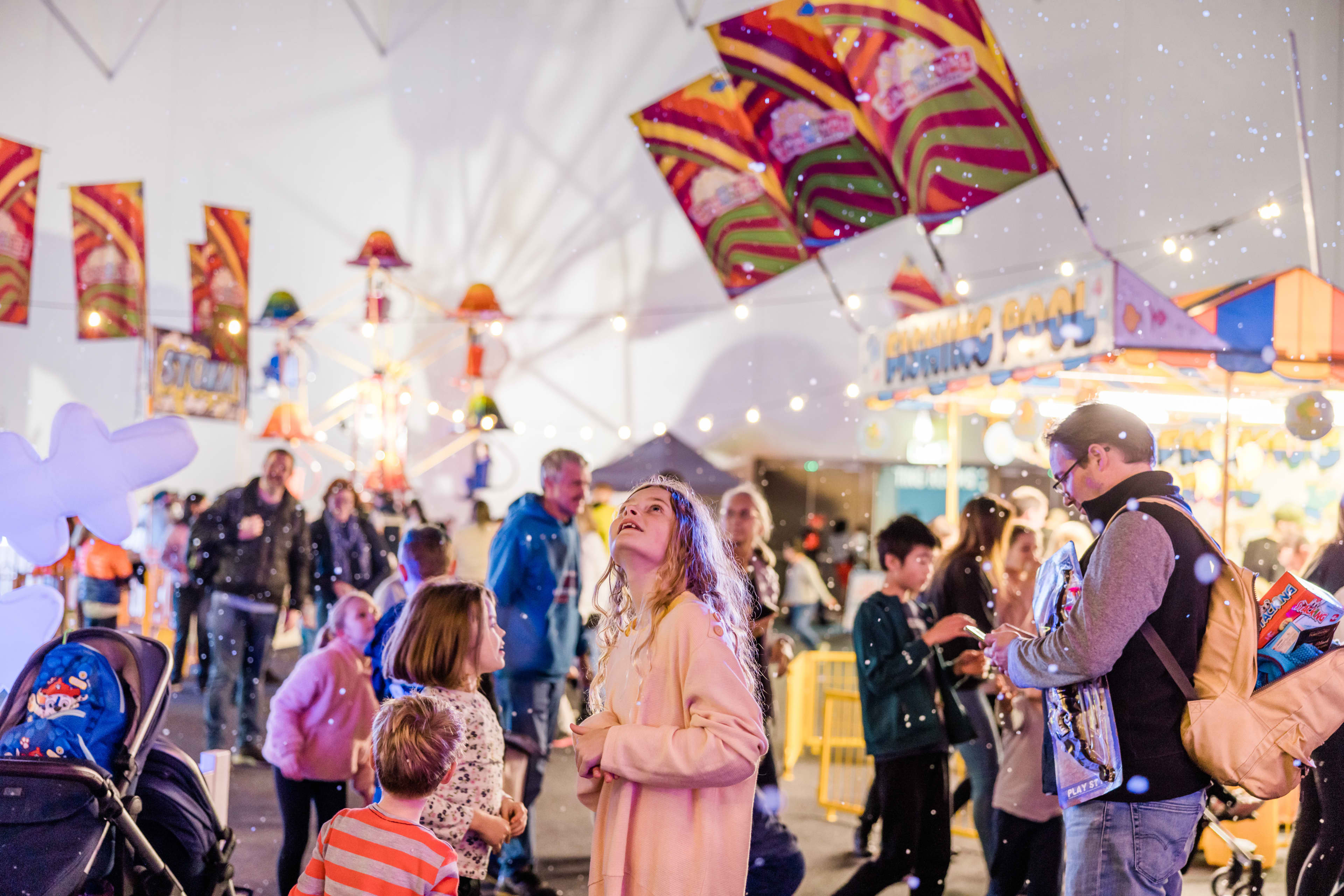 Crowd of people at an indoor winter festival.